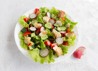 Fattoush salad with cucumber, tomatoes, radishes and toasted pita bread. Top view.