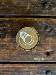 Top view of a tin can with an easy open lid on top of a wooden bench.