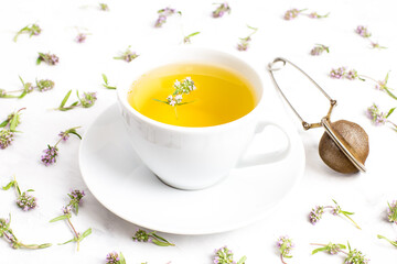 A Cup of tea with thyme flowers on a white background. The view from the top. Concept of folk medicine. Herbal drink.