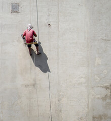 The master repairs the wall. Putting plaster on the wall. Male builders at work.