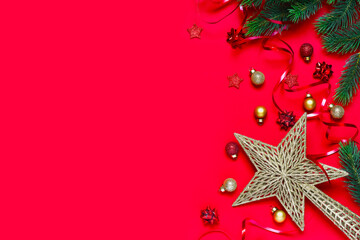 Christmas composition. Christmas red decorations, fir tree branches on red background. Flat lay, top view, copy space. Winter holiday theme. Happy New Year 2021. Space for text