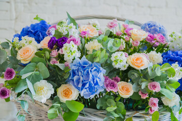Large floral basket with colorful flowers at workshop, flower shop. Floristry, holiday, romantic, celebration, handmade and small business concept