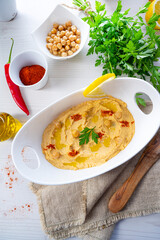 hummus paste with lemon and chilli on white background