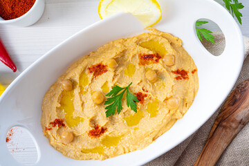 hummus paste with lemon and chilli on white background