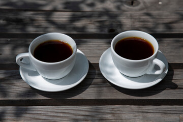 Two cups of coffee filter on a wooden table, side view
