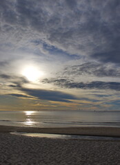 The sun is rising over the sea and beach