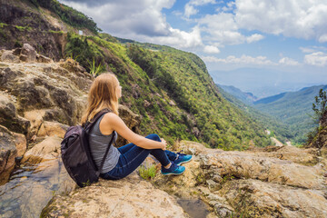Fototapeta premium Woman hiker on a rock. View of the valley from the cliff, Vietnam, Da Lat