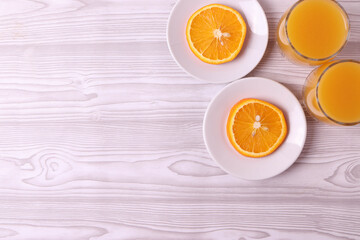 sliced fresh citruses and orange juice on the light rustic wooden surface. top view