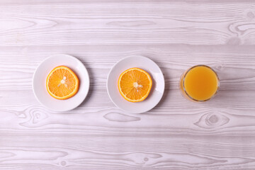 sliced fresh citruses and orange juice on the light rustic wooden surface. top view