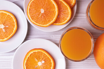 sliced fresh citruses and orange juice on the light rustic wooden surface. top view