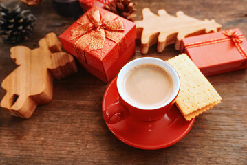 Top angle view red coffee cup with biscuits decorate with gifts box on the table for Christmas party. 