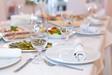 Tasty dishes on a served white banquet table in a luxury restaurant. No people.