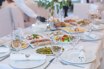 Tasty dishes on a served white banquet table in a luxury restaurant. No people.