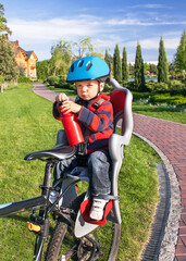 Fototapeta premium Baby boy is in the bicycle chair (seat).
