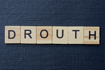 text on word drouth from gray wooden letters on a black background
