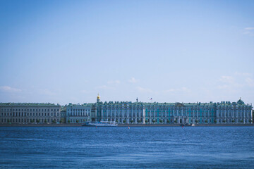 Beautiful buildings of the city of St. Petersburg on the banks of the Neva River on a clear sunny day against a blue sky