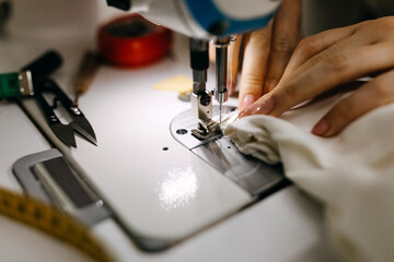 Tailor working at a sewing machine, soft focus on needle.