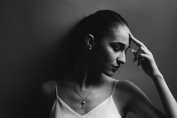 Obraz premium Beauty fashion portrait of a pretty young woman with eyes closed. Black and white photo. Woman in a tshirt posing in the studio, head turned to the side
