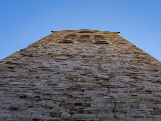 Fototapeta na wymiar Alte Mauer, Kirchturm mit Uhr und blauem Himmel