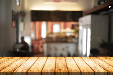 Empty wooden desk space and blurry background of cafe or Restaurant for product display montage.