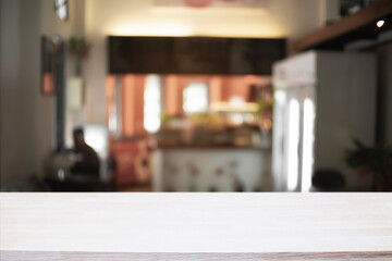 Empty wooden desk space and blurry background of cafe or Restaurant for product display montage.