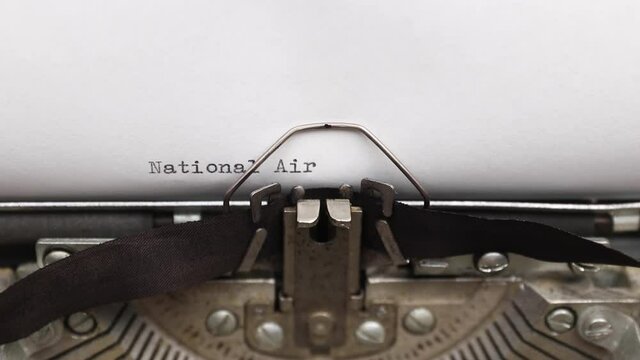 Typing a phrase National Airborne Day on a vintage typewriter close-up. concept of festive banner for professional holiday
