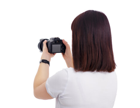 back view of female photographer or videographer shooting video or photos on her camera isolated on white