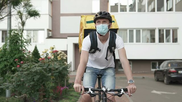Courier delivery of food by bicycle during an outbreak of the virus. Coronavirus, COVID-19, safe delivery.