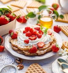 Homemade waffles with the addition of whipped cream and fresh strawberries, close up view