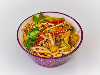 Udon noodles with meat in a plate on a white surface. With vegetables greens