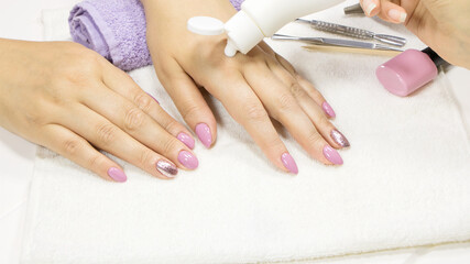 The manicurist applies a moisturizer to the client's hand. SPA manicure, procedure, moisturizing. Hand lotion, cream. Skin care. Beauty salon. Manicure concept. Beauty nails. Soft skin. Cosmetic cream