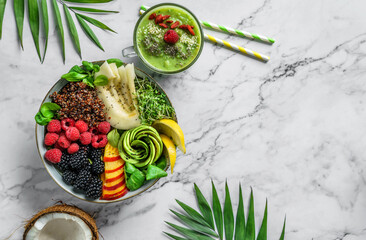 Fresh summer salad with quinoa, peach, micro greens, avocado, berries, coconut, melon on light...
