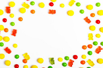 frame of multicolored round candies and jelly bears on a white background. sweets store concept. Beautiful background for the designer. sweets concept for kids. flat lay, copy space..