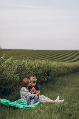 Big young happy family in the field on the nature. Mom, dad and 2 sons are having fun, running, fooling around together. Happiness and smiles around