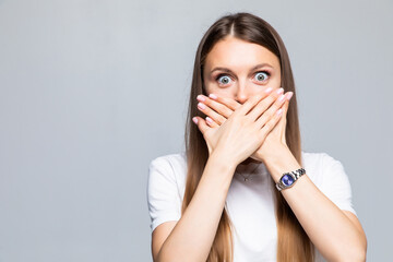 Portrait of young woman covering mouth with hand on white background