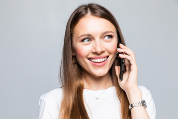 Smiling woman talking on the phone isolated on a grey background