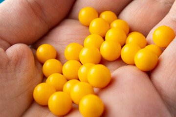 Yellow round pills on palm close up