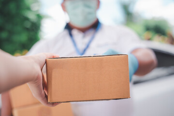 Male delivery workers wear sanitation faces and wear gloves to deliver goods or parcels by...