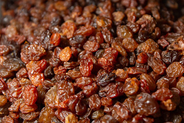 Closeup of raisins, dried dark grapes, shriveled dried berries.