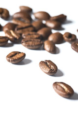 Fototapeta premium Roasted coffee beans isolated on white background - detail. Close up of a brown bean of aroma black caffeine drink ingredient for coffee beverage.