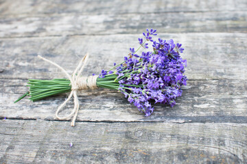 small lavender bouquet on old rustic wooden table, banner copy space, fresh aromatic herbs
