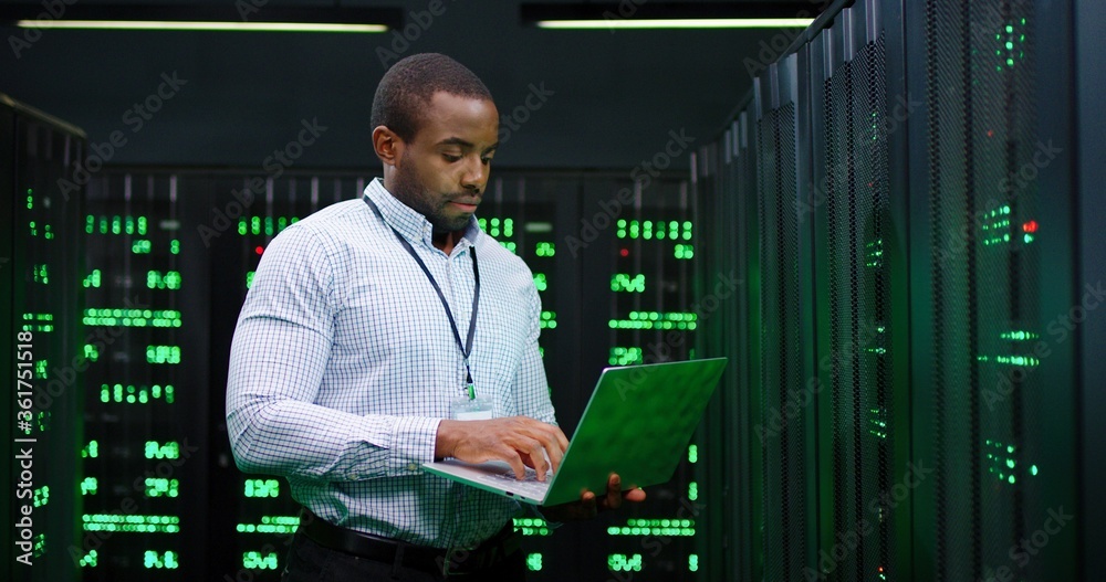 Wall mural male african american big data analytic walking at server dark room, working with secret data and us