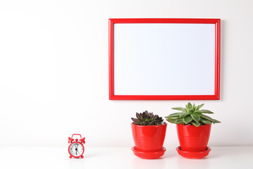 Red and white frame poster with plant in pot on table.