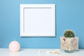 Fototapeta na wymiar White frame mock up on a book shelf. Bright colors.