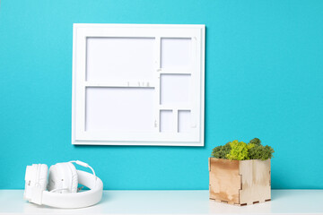 white blank frame, plant cactus with shells on white table against the blue wall. Mockup with copy space
