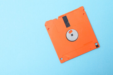 Floppy orange 3.5 on a blue background. Floppy disk general plan and close-up.