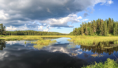 Blue mirror lake reflections of clouds and landscape. Sudbury, Ontario, Canada.