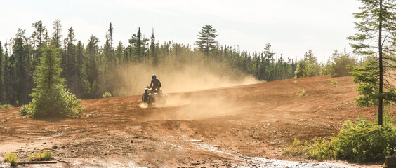 Man driving ATV quad in sandy terrain with high speed. © Drepicter