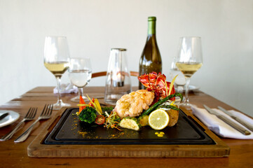  Lobster cooked with vegetables accompanied with a glass of white wine