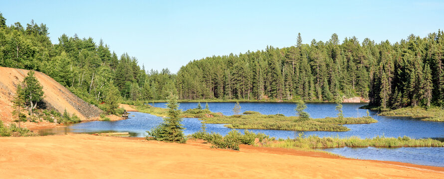 Idyllic Blue lake and forest landscape in evening sunset sunlight. Foy, Foyross Lake, Sudbury, Ontario, Canada.
